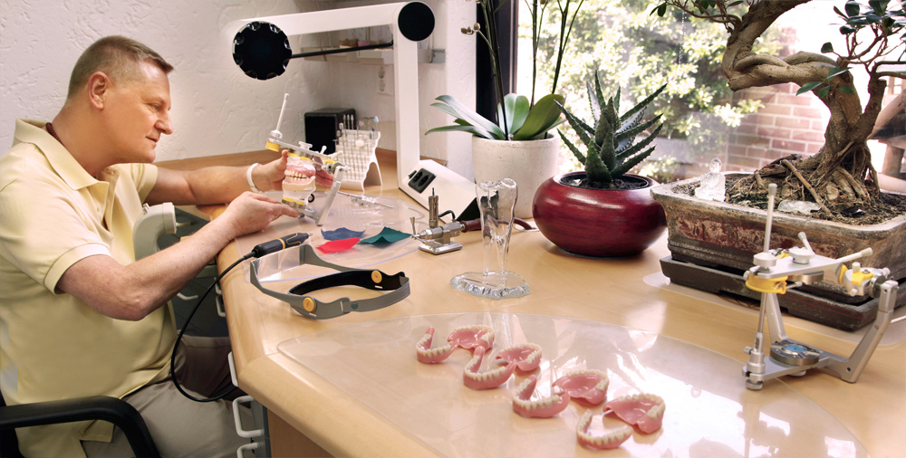 Mike Moll voert een precieze reparatie aan een kunstgebit uit in het atelier van TPP Venlo